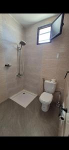 a bathroom with a toilet and a shower with a window at Thiam APPART in Nouakchott