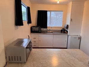 a kitchen with a refrigerator and a sink in it at Wairoa Motel in Wairoa