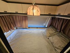 a small bed in the back of an rv at Full Service Caravan 1 in Albertslund