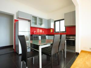 una cucina con un tavolo di vetro e sedie nere di Skyline Villas RC a Calheta
