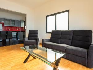 un soggiorno con un divano e un tavolo di vetro di Skyline Villas RC a Calheta Altre 2 foto