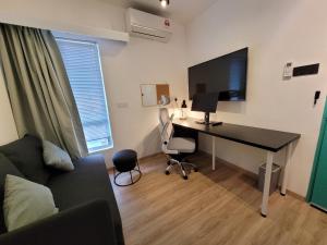 a living room with a desk with a computer and a couch at Nomad Shophouse in Kuala Lumpur +4 photos