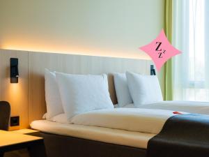 a bed in a hotel room with a pillow with a z number on it at Citybox Kristiansand in Kristiansand