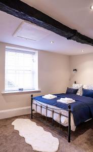 テュークスベリーにあるTysoes Court Tewkesburyの青いベッドと窓のある寝室