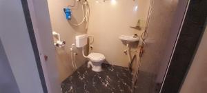 a small bathroom with a toilet and a sink at Gokarna Holiday Homes in Gokarna +20 photos