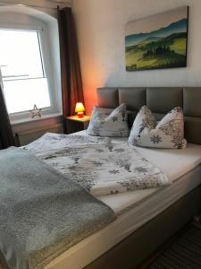 a bedroom with a bed with pillows and a window at Bergapartments in Kurort Oberwiesenthal