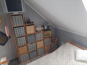 a room with a bed and a shelf with boxes at Pokoje u ANI B in Otmuchów