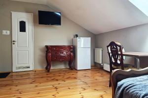 a room with a refrigerator and a table and a chair at Spichlerz Ostoya in Jasionka