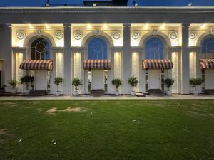 a large building with a lawn in front of it at Torque Stays in Noida