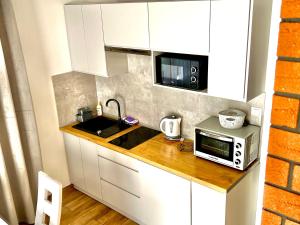 a small kitchen with a microwave and a sink at Domki przy Potoku in Suche