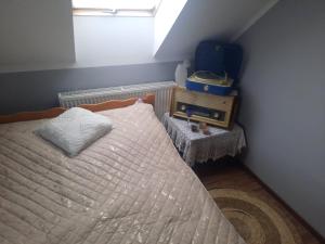 a small bedroom with a bed with a window at Pokoje u ANI B in Otmuchów
