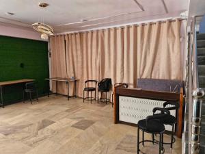 Cette chambre comprend des chaises, une table et des rideaux. dans l'établissement Hotel O Agrawal Inn, à Jabalpur