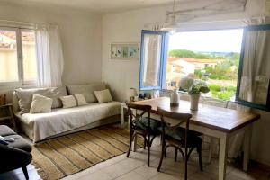 un salon avec une table et un canapé dans l'établissement 1Bed Cottage Sleeps 4- Sea Views Balcony Parking, à Mèze