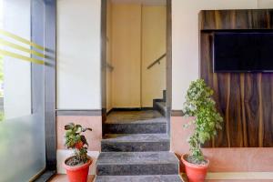 a hallway with two potted plants on the stairs at Townhouse Andheri Sakinaka Metro Formerly Hotel Amour in Mumbai