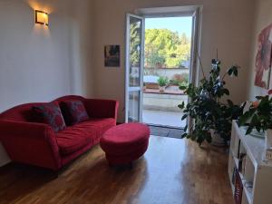 a living room with a red couch and a red stool at Lodges le Mura 2 in Florence