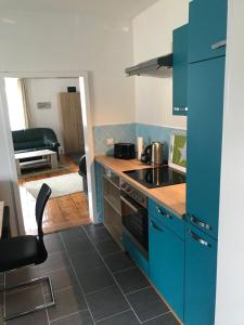 a kitchen with blue cabinets and a stove top oven at Bergapartments in Kurort Oberwiesenthal