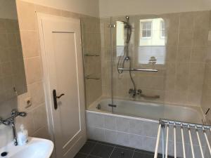 a bathroom with a shower and a tub and a sink at Bergapartments in Kurort Oberwiesenthal +58 photos