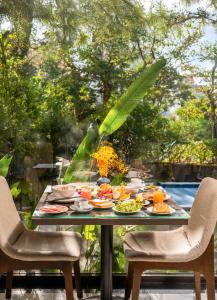 a table with food on it with two chairs at JM Hoi An Beach Hotel - Free Shuttle Car To Old Town in Hoi An