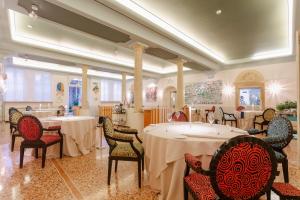 a dining room with two tables and chairs at Byblos Art Hotel Villa Amistà in San Pietro in Cariano
