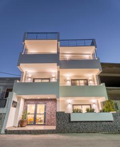 a three story building with two balconies at Naiades Guest House in Sálakos
