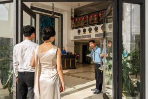 a man and a woman looking in a store window at JM Hoi An Beach Hotel - Free Shuttle Car To Old Town in Hoi An