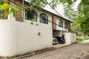 a white building with cars parked outside of it at Tuluscoliving Villa Kuta 1, 4 Bedroom & 5 Bathroom in Ngurah Rai International Airport