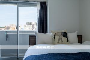 Un dormitorio con una cama con vistas a una ciudad. en VIDA Hakata, en Fukuoka 35 fotos más