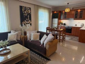 a living room with a couch and a kitchen at Ntarmos Apartment in Sparti