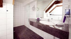 a bathroom with a sink and a mirror at Home Hotel Skagen Brygge in Stavanger +37 photos