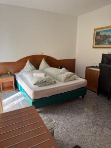a bedroom with a bed with a wooden headboard at Hotel & Restaurant Garda in Darmstadt
