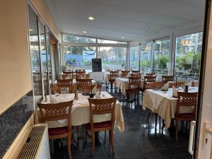 a dining room with tables and chairs and windows at Hotel & Restaurant Garda in Darmstadt