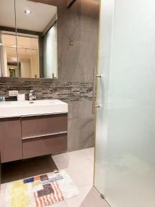 a bathroom with a shower and a sink and a mirror at Sands Condo Pattaya-Seaview by the Beach in Pattaya South
