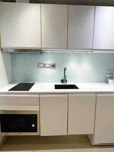 a kitchen with white cabinets and a sink at Sands Condo Pattaya-Seaview by the Beach in Pattaya South