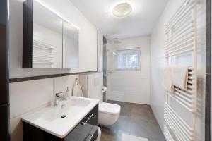 a white bathroom with a sink and a toilet at Ferienapartment Karle in Nordrach +17 photos