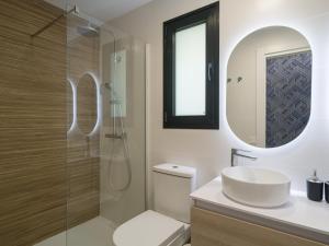 een badkamer met een toilet, een wastafel en een spiegel bij Sunset Arguineguin by CanariasGetway in Arguineguín +56 foto's