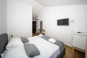 a bedroom with a bed and a tv on the wall at Room accomodation Jezera Lovišća in Jezera
