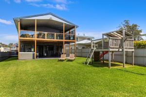 een huis met een glijbaan en een speeltuin bij Whale Watcher - Beachfront with Spa in Culburra Beach