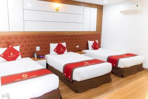 Habitación de hotel con 3 camas con almohadas rojas en Bình Long II Hotel, en Lai Châu