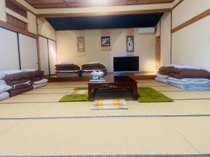 a living room with couches and a tv at フクロウの御宿 石和館 in Fuefuki +16 photos
