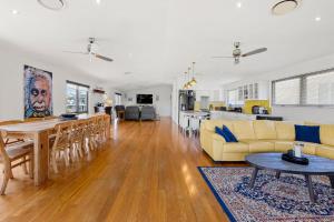 een woonkamer met een tafel en een eetkamer bij Whale Watcher - Beachfront with Spa in Culburra Beach