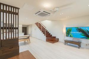 ein Wohnzimmer mit einer Treppe und einem TV in der Unterkunft Aewol Damdam Stay in Sowang-dong