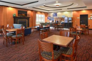 a restaurant with tables and chairs and a bar at Holiday Inn Express Hotel & Suites Royse City - RockwallRockwall - Royse City by IHG in Royse City