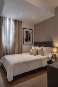 a bedroom with a large white bed with a window at ®{LUX~City~Skyline} @DowntownSD PrivéJaccuziGym in La Julia