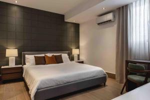 a bedroom with a large bed and two lamps at ®{LUX~City~Skyline} @DowntownSD PrivéJaccuziGym in La Julia +42 photos