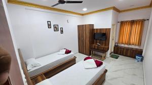 Habitación con 2 camas y TV. en Guru residency, en Bangalore