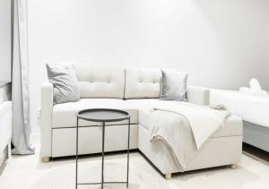 a white bedroom with a white couch and a table at Togton Premium Suite Växjö in Växjö +8 photos