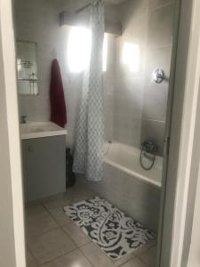 a bathroom with a bath tub and a sink at 120 steps to the beach in Pringle Bay
