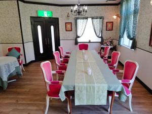a conference room with a long table and pink chairs at utena IZUKOUGEN in Ito