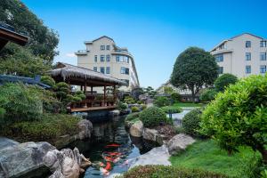 een tuin met een vijver met vliegers erin bij Floral Luxury Hengdian Jiuqilu B&B in Longfengshan