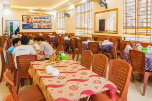 two people sitting at tables in a restaurant at Trường Sa Hotel Cửa Lò Beach in Cửa Lò